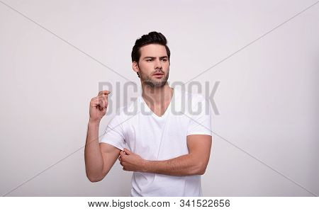 A Simatic Young White Guy With Dark Hair And Dark Eyes, With A Sports Figure In A White T-shirt, Tou