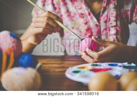 Young Girl Painting Easter Eggs For Eastertime At Home
