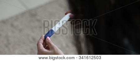 Focus On Tender Female Hands Holding Undone Pregnancy Test. Woman Checking Childbearing And Looking 