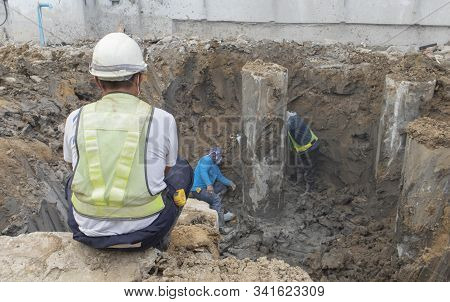 Two Workers Are Helping To Cut The Steel Wire By Gas In The Concrete Pile.