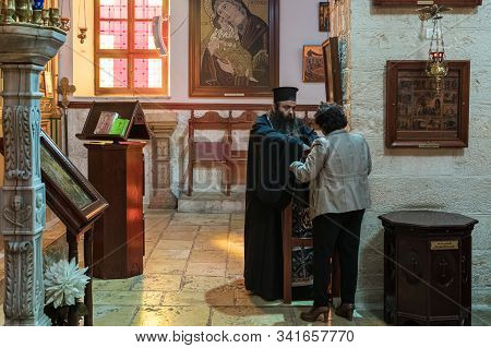 Jerusalem, Israel, December 28, 2018 : Priest Talks With A Parishioner In St. Nicholas Church After 