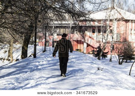 A Silhouette Of Man Move In Snowy Day. Concept Maniac. Winter Day. Park