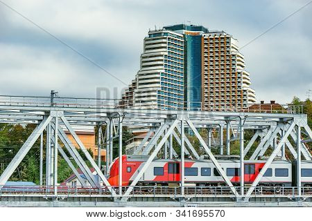 Sochi, Russia, October 10, 2019: Passenger Train On The Bridge By The Luxury Hotel.