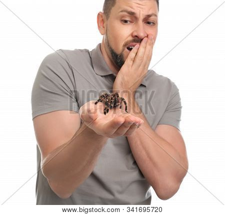 Scared Man Holding Tarantula On White Background. Arachnophobia (fear Of Spiders)