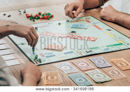 Kyiv, Ukraine - November 15, 2019: Cropped View Of Man And Women Playing Monopoly Game At Table