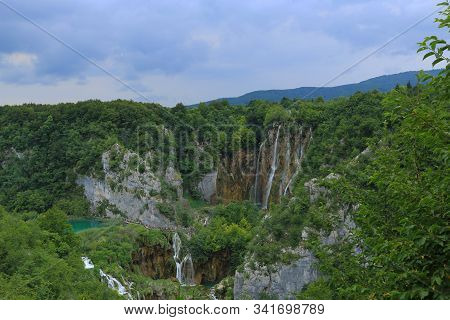 Small Waterfalls In The Wild Green Trees And River