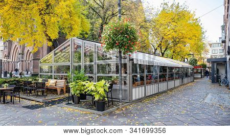 A Small Cafe In The Middle Of A Square With Glass Wall. Eindhoven, Netherlands.