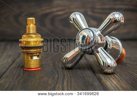 Cruciform Hot And Cold Water Main Switch Of Spare Parts On Black Wooden Boards