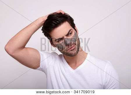 Male Wearing A Charcoal And Bentonite Clay Face Mask Beauty Treatment. Front Portrait Of A Male Wear