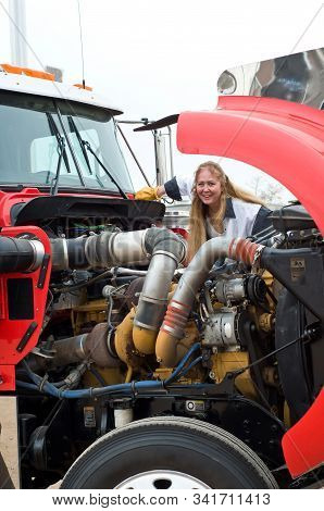 A Woman Truck Driver Checking Big Truck Before Driving It.