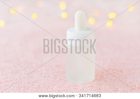 Natural Face Serum In A Glass Bottle On Pink Background With Bokeh, Soft Focus
