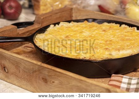 Shephers Pie Baked In A Cast Iron Skillet And Placed On A Wood Tray With An Apple And Napkins