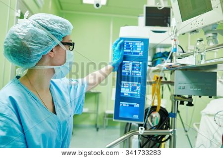 Surgery assistant perfusionist operating a modern heart lung machine