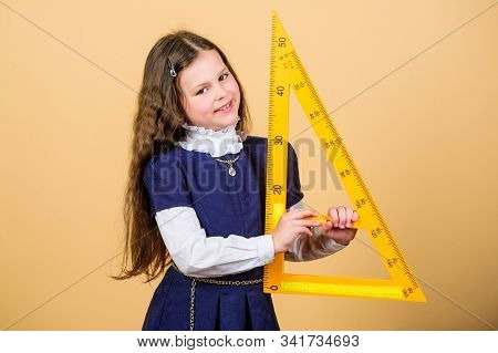Girl With Big Ruler. School Student Study Geometry. Sizing And Measuring. Kid School Uniform Hold Ru
