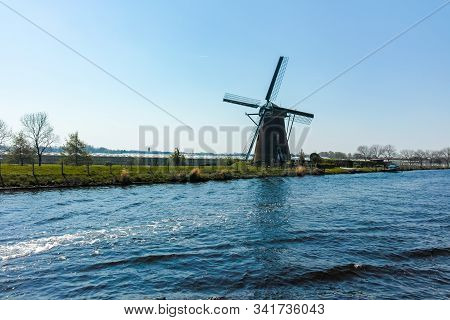 Waterways And Canals In North Holland With Boats And View On Traditional Dutch Mill, Spring Landscap