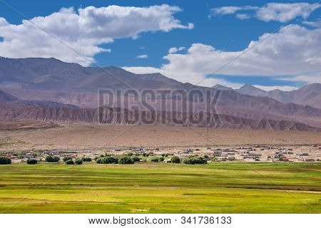 Landscape Of Barren Mountain Ranges,desert,pasture,village And Cloudscape In Pamirs Plateau In Xinji