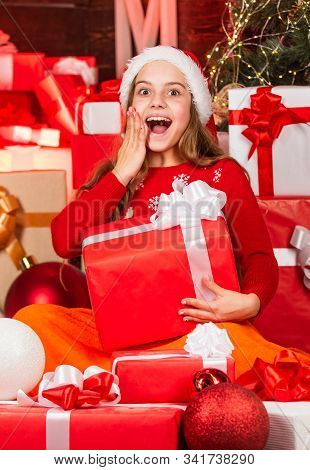 Kid In Santa Hat With Many Gift Boxes. Successful Shopping On Xmas Market. Decorated With Gifts. Sho