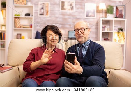 Old Eldelry Couple Using A Smartphone To Talk With Their Family