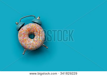 Pink Alarm Clock Donut On Blue Background. Breakfast Time Or Minimal Concept. Copy Space. Top View