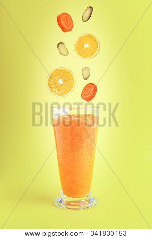 Smoothie And Falling Isolated Fruits And Vegetables For Its Preparation: Carrot, Orange, Ginger Root