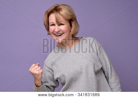 Senio Female Winner Raising Arm, Clenching Fist, Exclaiming With Joy