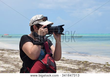 Pingwe, Zanzibar - October 6, 2019: Professional Woman Photographer Takes A Picture On A Beach, Tanz