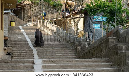 Masuleh, Iran - May 2019: Unidentified Old Iranian Woman Walking In The Roads Of Traditional Masuleh