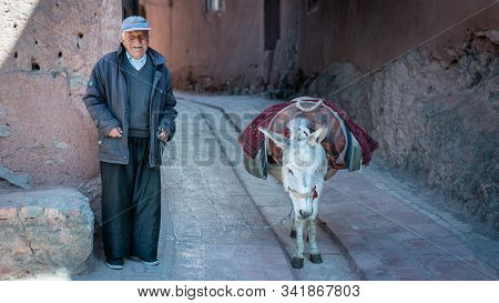 Abyaneh, Iran - May 2019: Old Man And His Donkey In The Traditional Village Of Abyaneh
