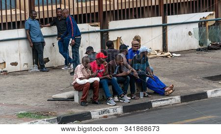 Johannesburg, South Africa - October 2019: Group Of People In Johannesburg Sitting Together By The R