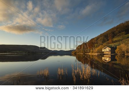 Stunning Sunrise Autumn Fall Landscape Image Of Ullswater In Lake District With Golden Sunlight