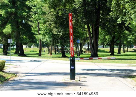 Two Closed And Open Automatic Red And White Striped Metal Ramps With Id Station And Security Cameras