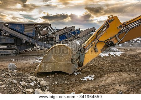 Stone Crusher And Excavator In An Open Pit Mine. Granite Mine To Make Gravel