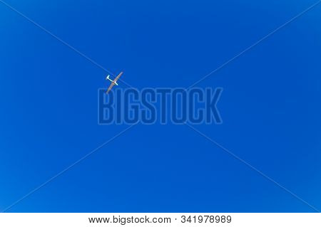 Flying A Sports Plane. The Sky Is Classic Blue Without Clouds.
Concept: Sport, Dream, Peace, Romance