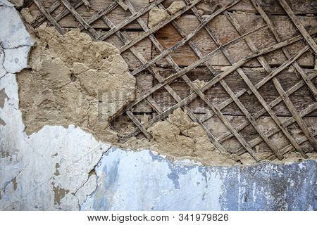 Wall Of An Old House With Peeling Stucco. Concept: Contrasting Modern Technology.
