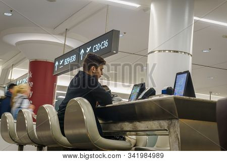 Lester Pearson International Airport, Toronto, December 2019 - Young Man Seated Using Electronic And