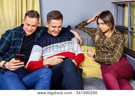 Girl Is Jealous Of Her Boyfriend To His Friend. A Woman Is Watching Bromance Of Guys. Young People P