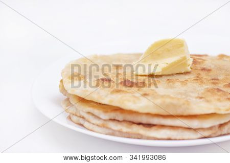 Chapatti, Tortilla, Fried In Oil In A Pan. Finished Dish. A Piece Of Butter Lies On Fried Flat Cakes