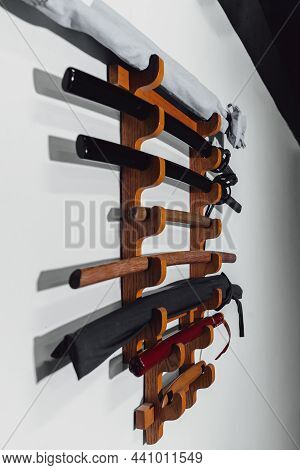 Special Stand On The White Wall For Training Swords Made Of Oak Wood And Iron. Traditional Japanese 
