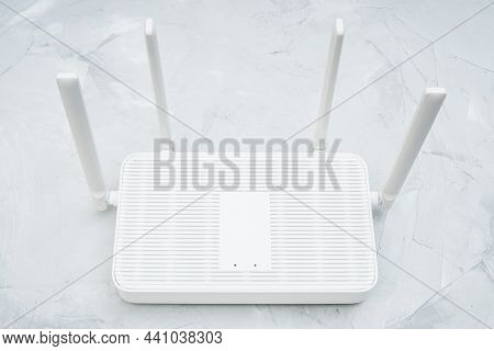 Top View Of A Dual Band Wi-fi 6 Router With Four Antennas Placed On A Concrete Table