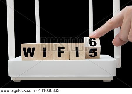 Finger Turning A Wooden Cube Illustrating The Transition From Wifi 5 To Wifi 6. Changing Infrastruct