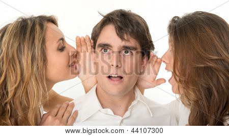 Due ragazze sussurrando nelle orecchie di un giovane uomo