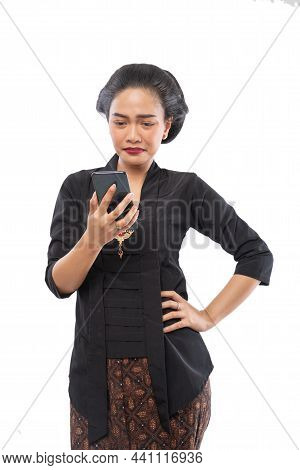 Sad Asian Woman With Traditional Javanese Dress Looking At The Screen Of A Phone
