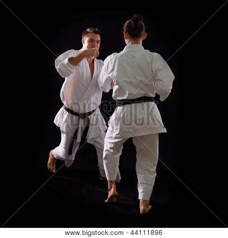 lotta karate coppia, uomo e donna con cinture nere - campioni del mondo, su sfondo nero