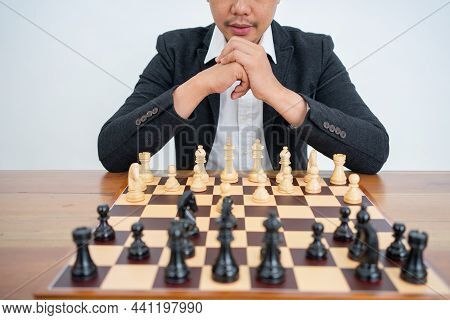 Chess Pieces On A Chessboard With A Master Playing Chess
