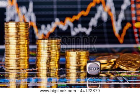 Downtrend กองเหรียญทอง Dices Cube หยุดคำและแผนภูมิทางการเงินเป็นพื้นหลัง Sele