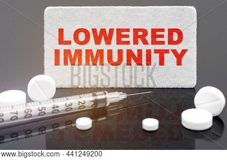 Medicine And Health Concept. On A Black Reflective Surface, Pills, A Syringe And A Sign With The Ins