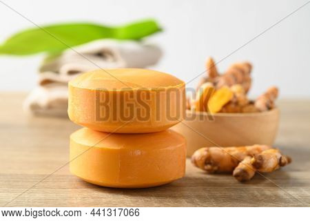 Turmeric Soap And Fresh Turmeric Root In A Bowl On Wooden Table With White Background, Herbal Organi
