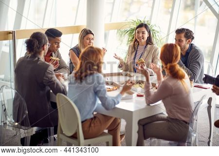 Group of young business people is enjoying a lunch break at the job in a friendly atmosphere together. Business, people, company