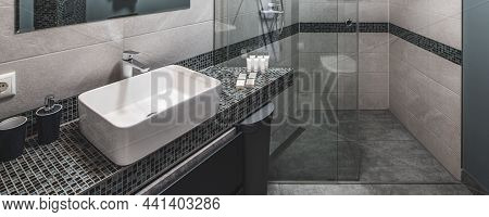 Contemporary Interior Of Bathroon In Modern Flat. Grey Colors. White Sink. Glass Shower Cabin.