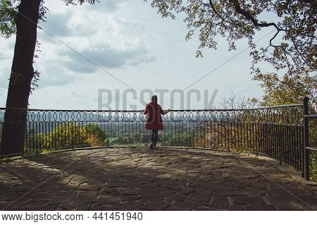 Young Woman Standing In Beautiful Park In The City Of Przemysl On A Sunny Clear Day Against A Bright